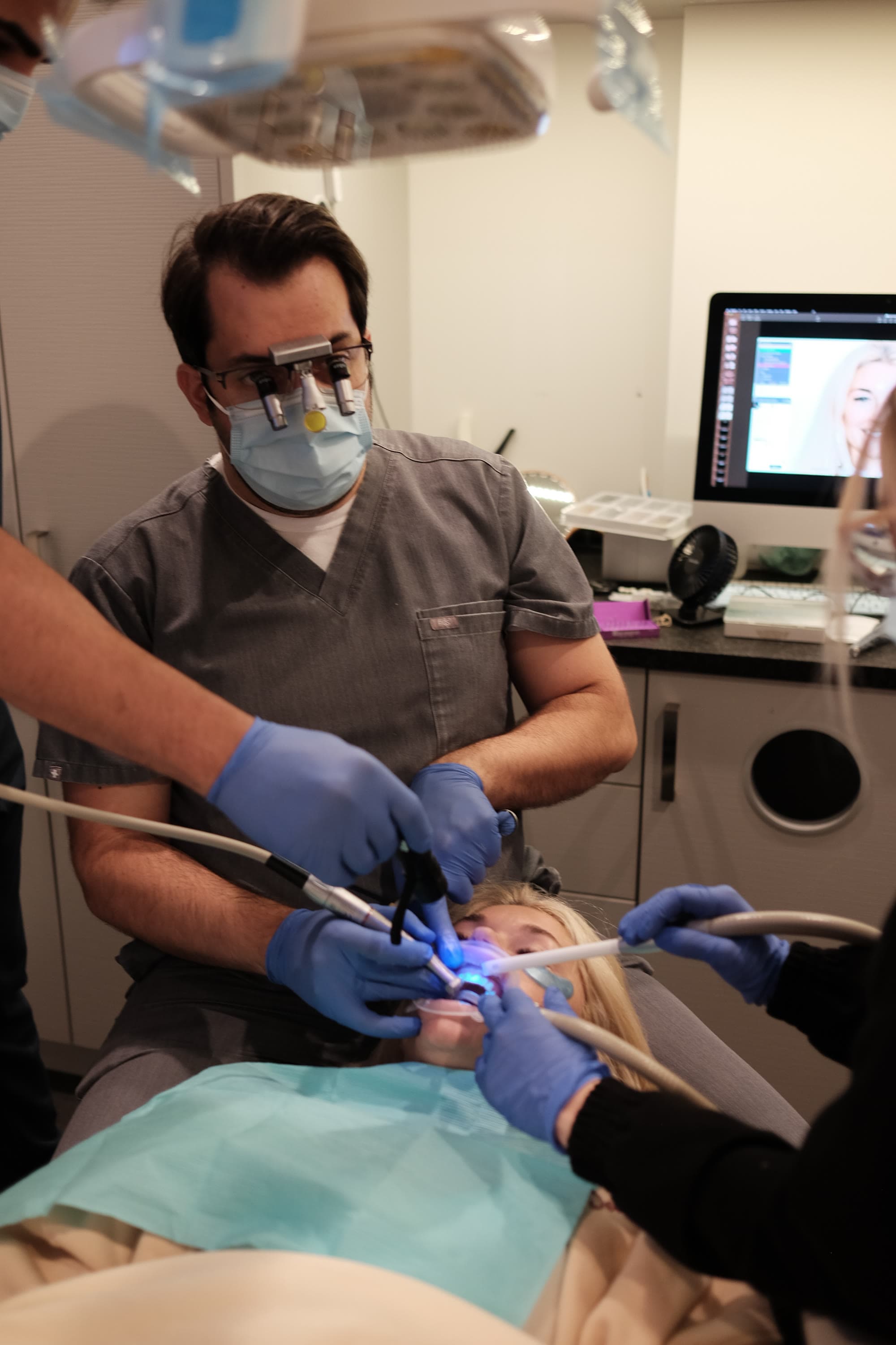 Dr. Atassi under loupes, working on a patient