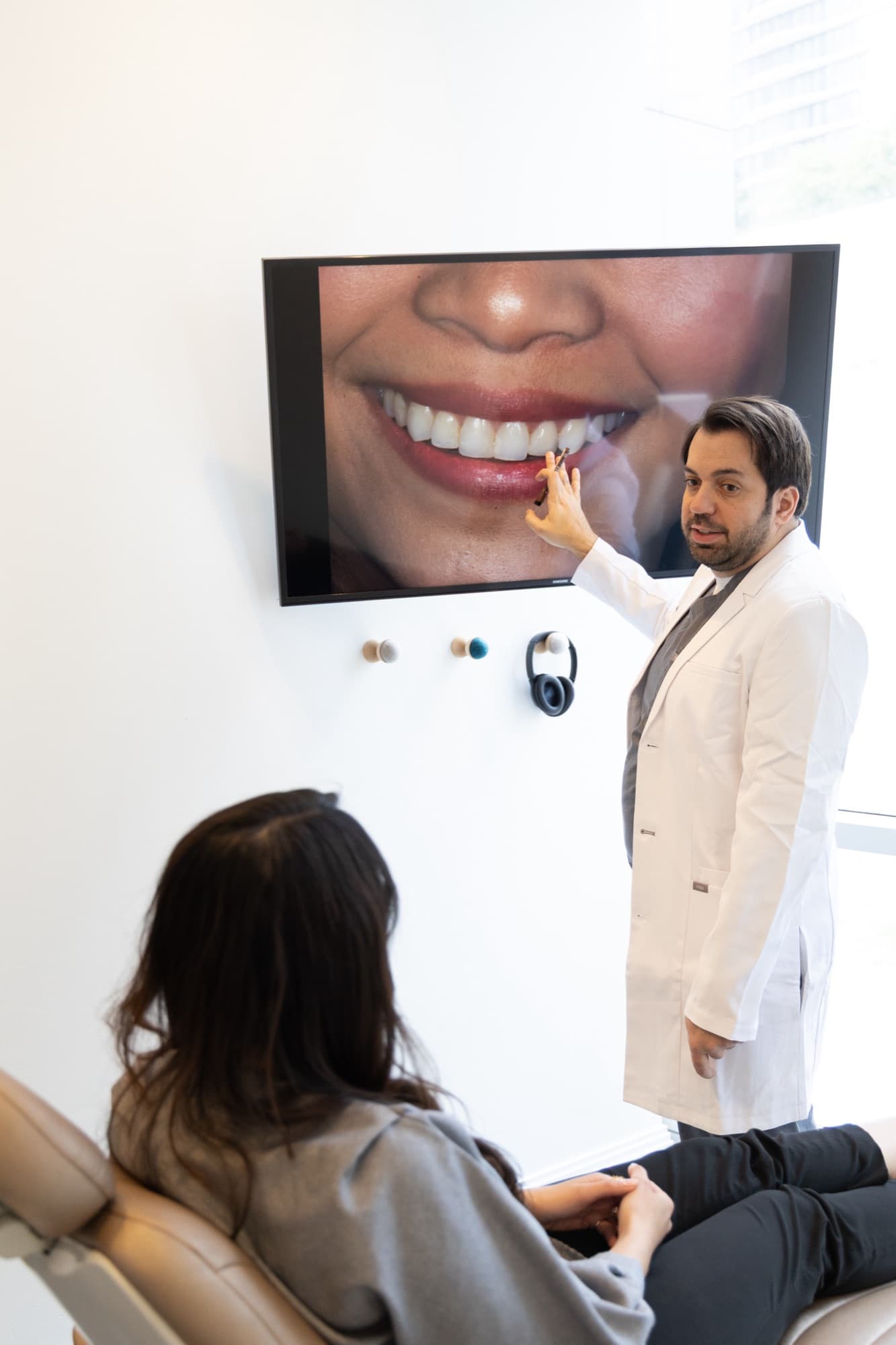 Dr. Atassi reviewing a smile photograph on screen with a patient