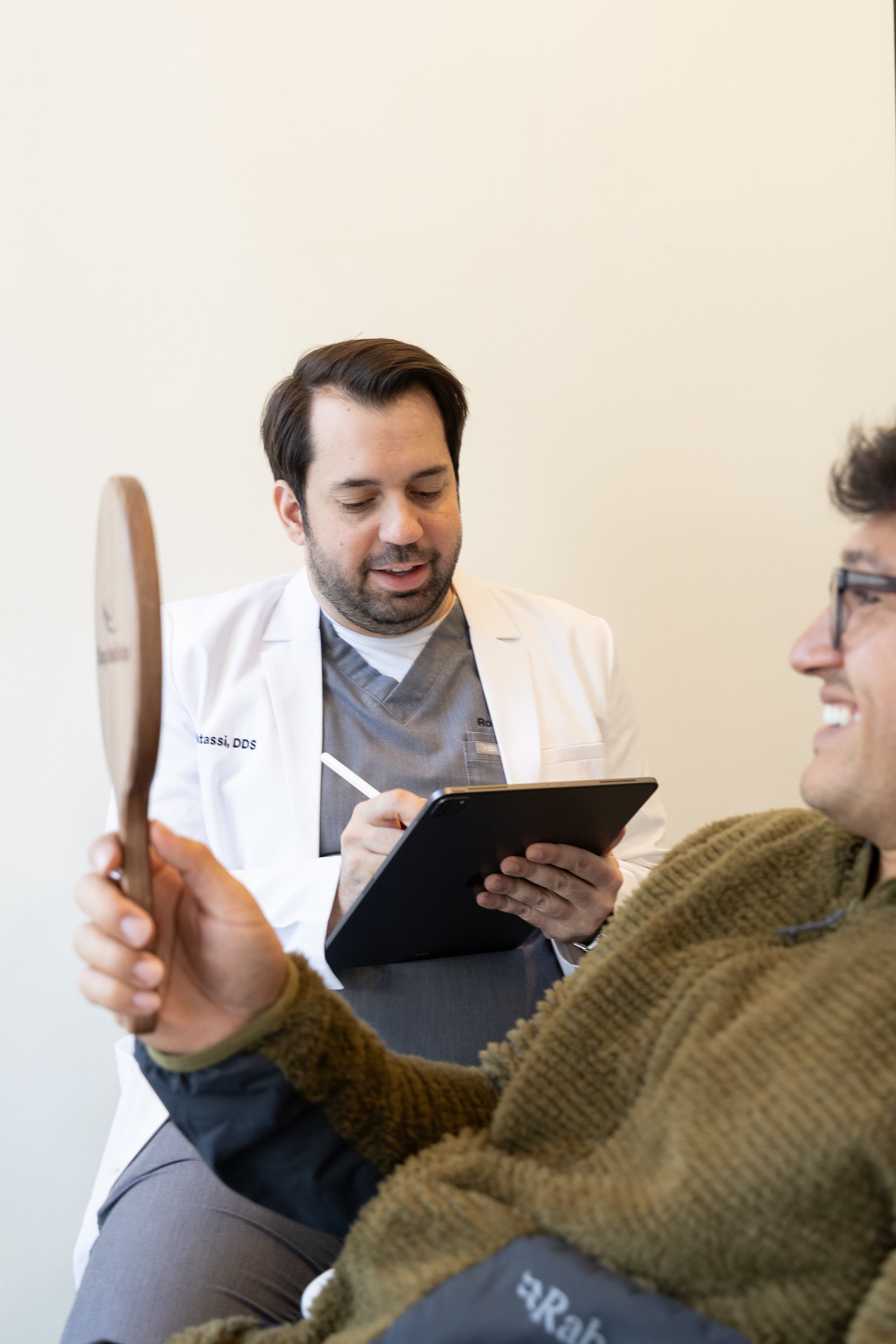 Dr. Atassi sketching a smile design on a tablet
